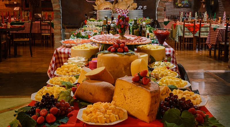 Mesa farta da Noite Italiana com queijos e vinhos